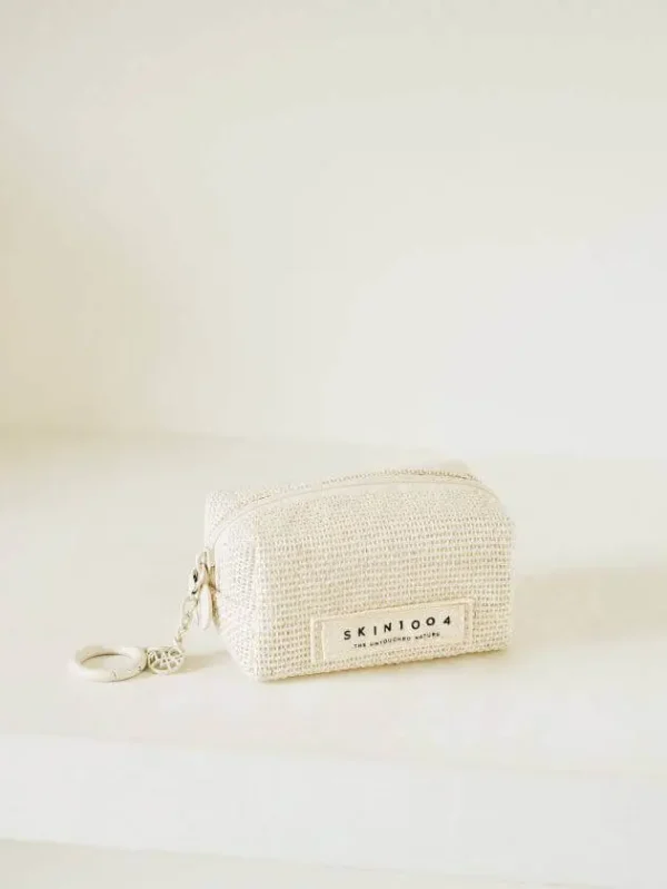 Skin1004 Mini Keyring Pouch made of natural fabric, zipped and placed on a minimalist cream surface